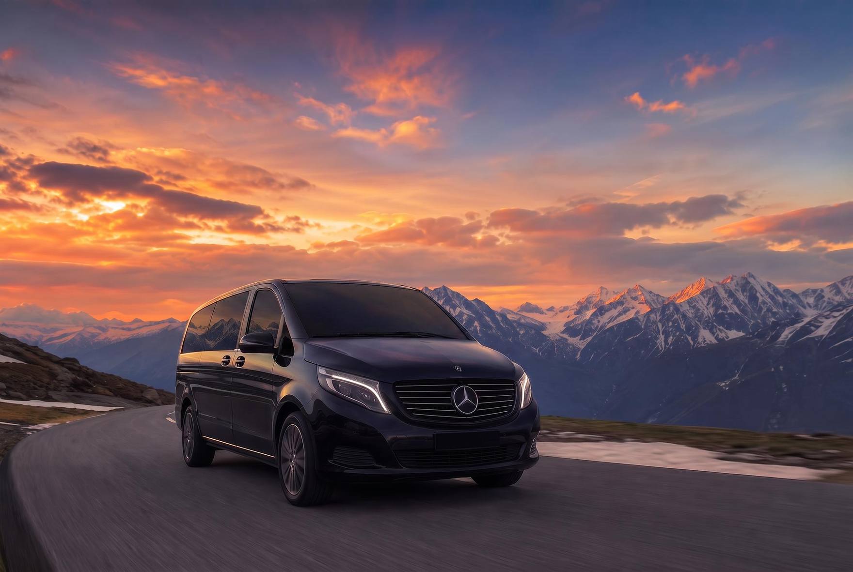 Black Mercedes V-Class on an Alpine mountain road at sunset